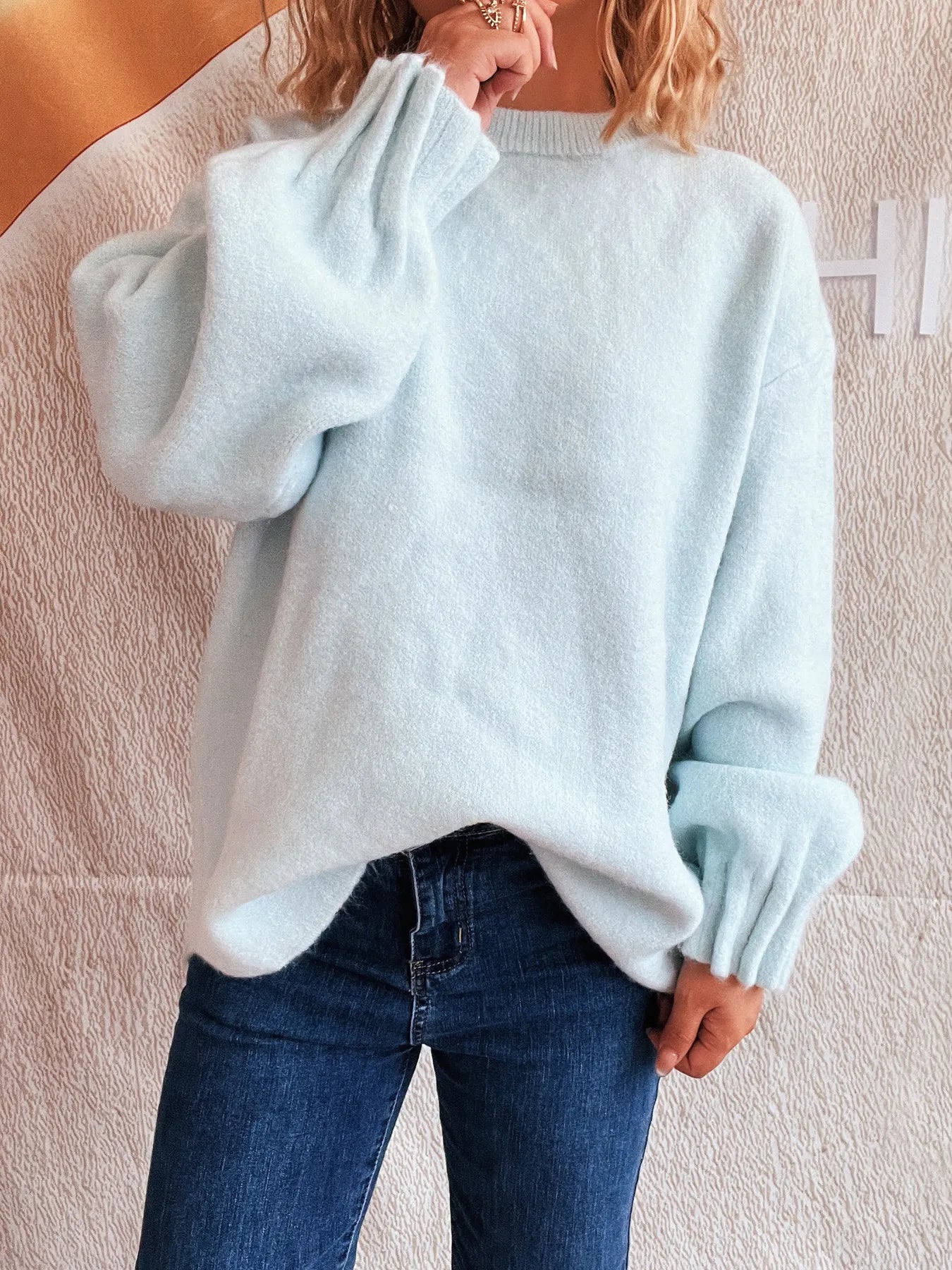 Light blue dropped shoulder sweater with round neckline and ribbed sleeve cuffs
