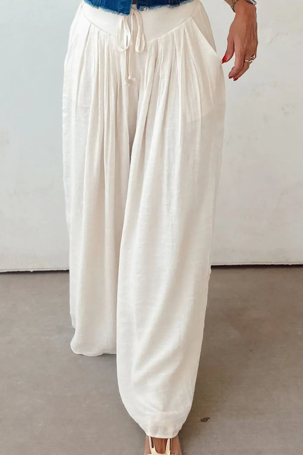 White wide-leg pants with tie waist, front pintuck pleats, and elasticized waistband