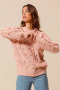 Blush pom-pom textured knit crewneck sweater with long sleeves and ribbed cuffs