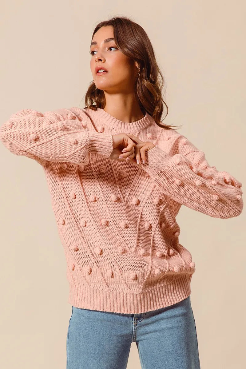 Blush pom-pom textured knit crewneck sweater with long sleeves and ribbed cuffs