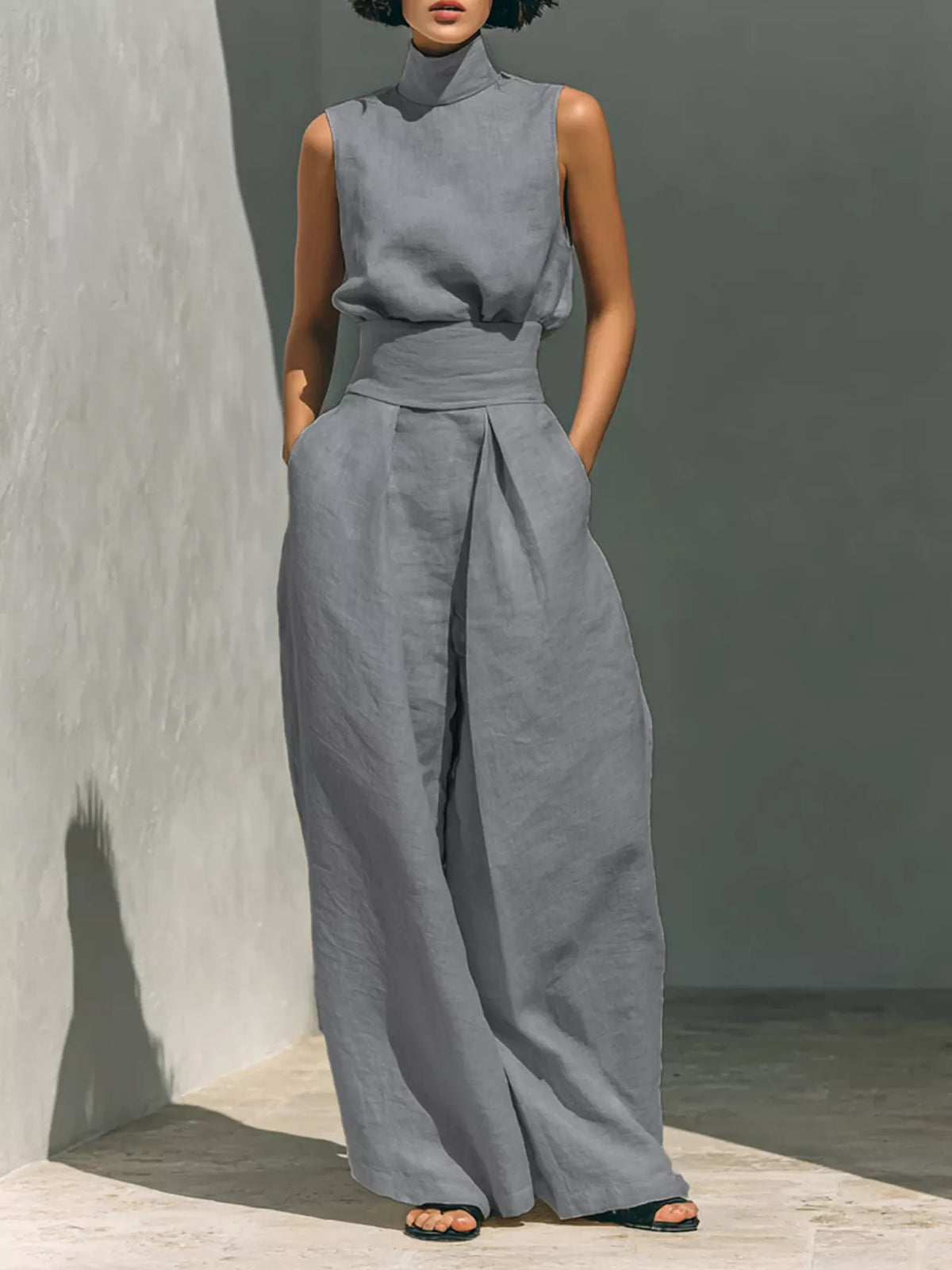 Sleeveless wide-leg jumpsuit in light gray with smocked waist and high neckline