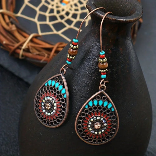 Copper teardrop beaded earrings with turquoise accents and ornate circular medallion