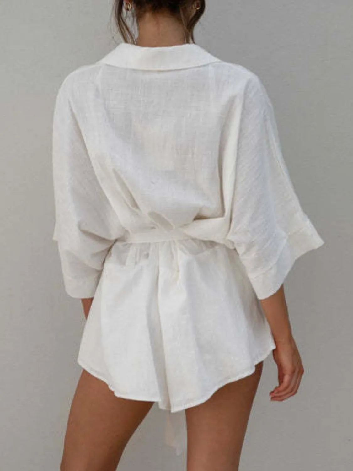 White collared half-sleeve romper back view with tie belt at waist