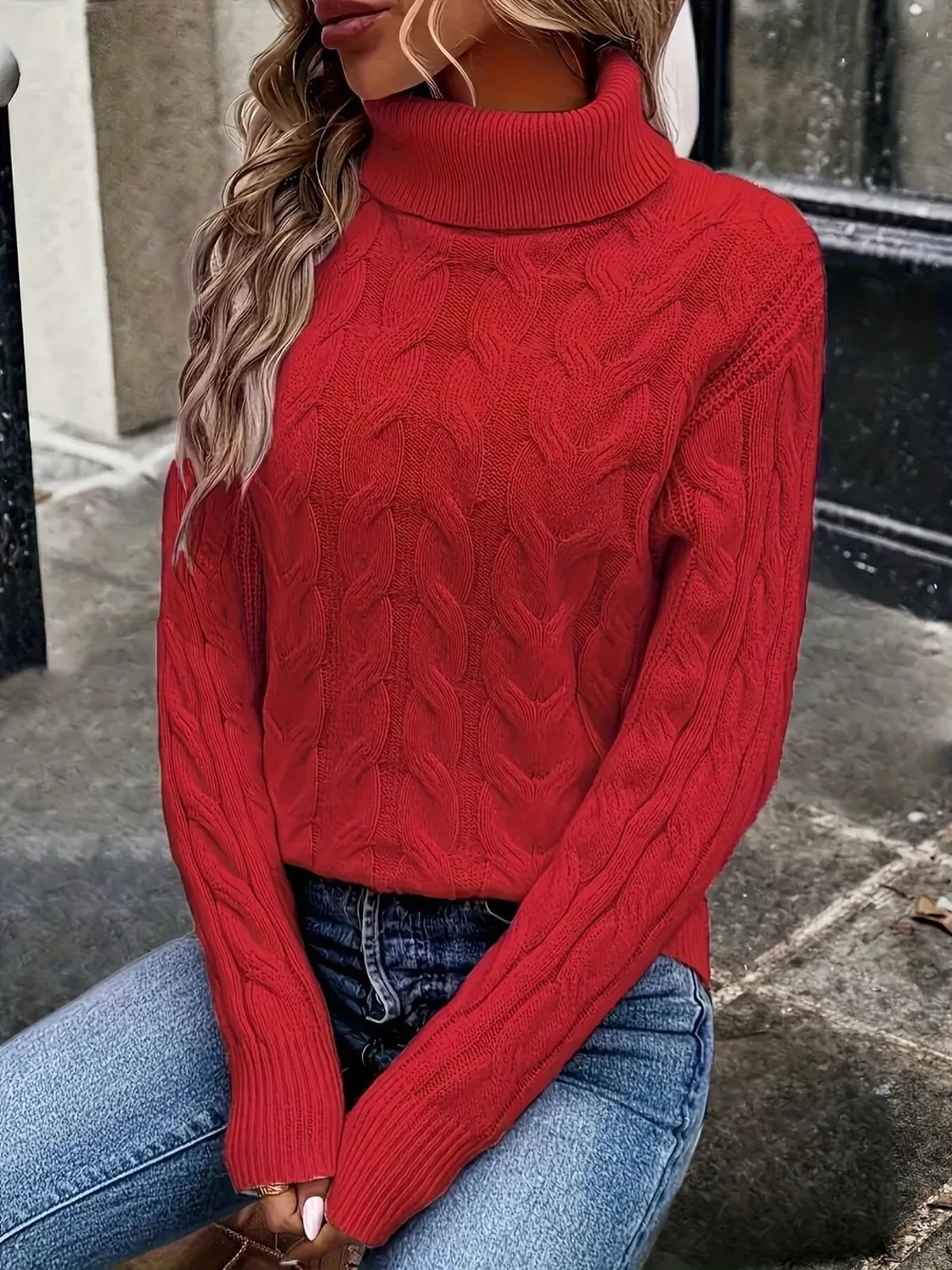 Red cable knit turtleneck sweater with long sleeves and textured cable pattern
