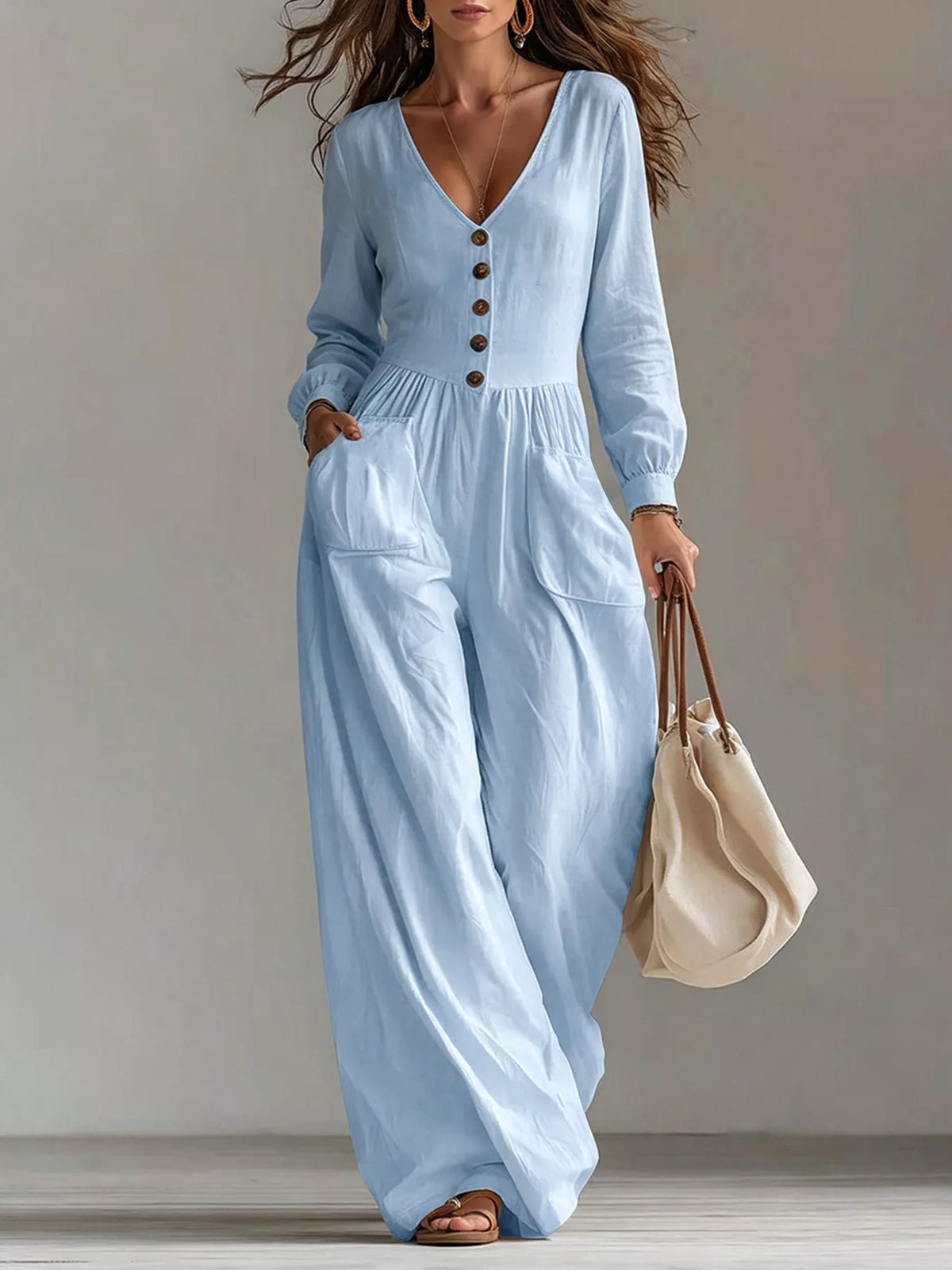 Light blue V-neck button-front long sleeve jumpsuit with wide legs and front pockets