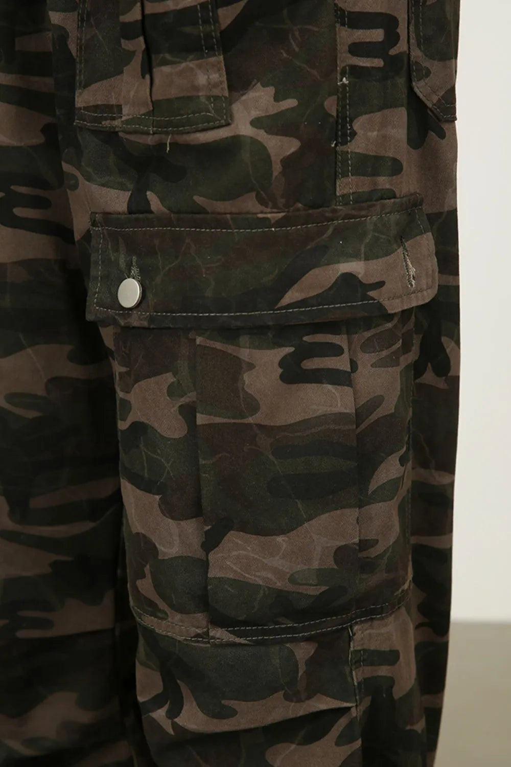 Green camouflage cargo jean fabric with stitched flap pocket and button closure