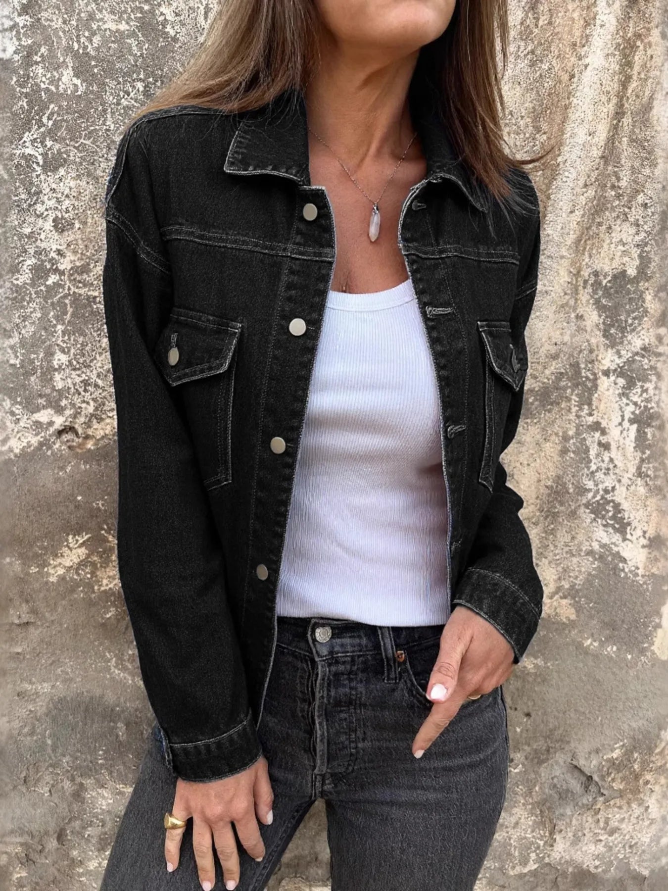 Black denim jacket with button front, pointed collar, and flap chest pockets