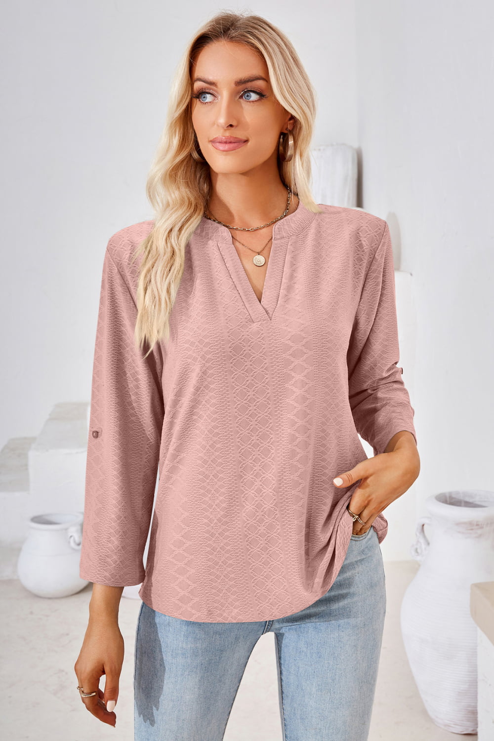 Dusty pink V-neck blouse with roll-tap sleeves and subtle textured print.