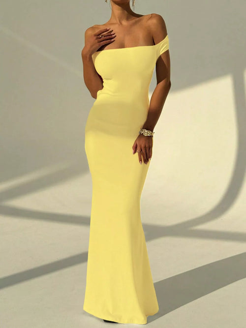 Yellow off-shoulder backless mermaid maxi dress with fitted waist and flared hem.