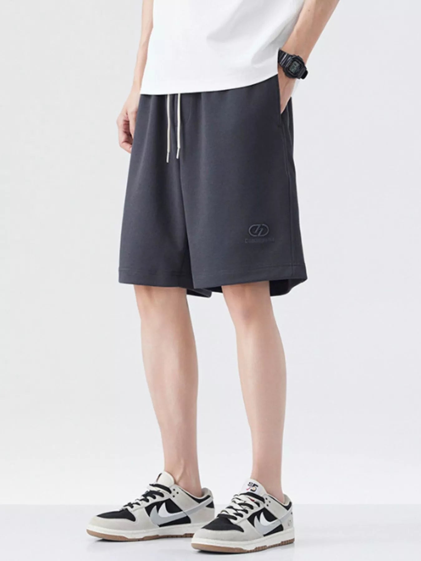 Dark gray drawstring loose-fit shorts with side logo and relaxed knee-length fit