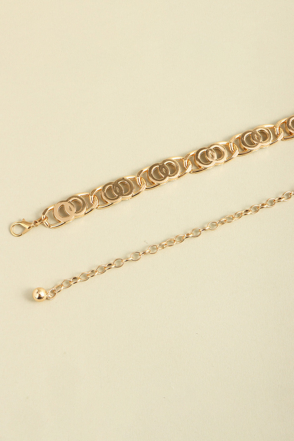 Gold lobster clasp belt detail with oval-link chain and ring clasp end
