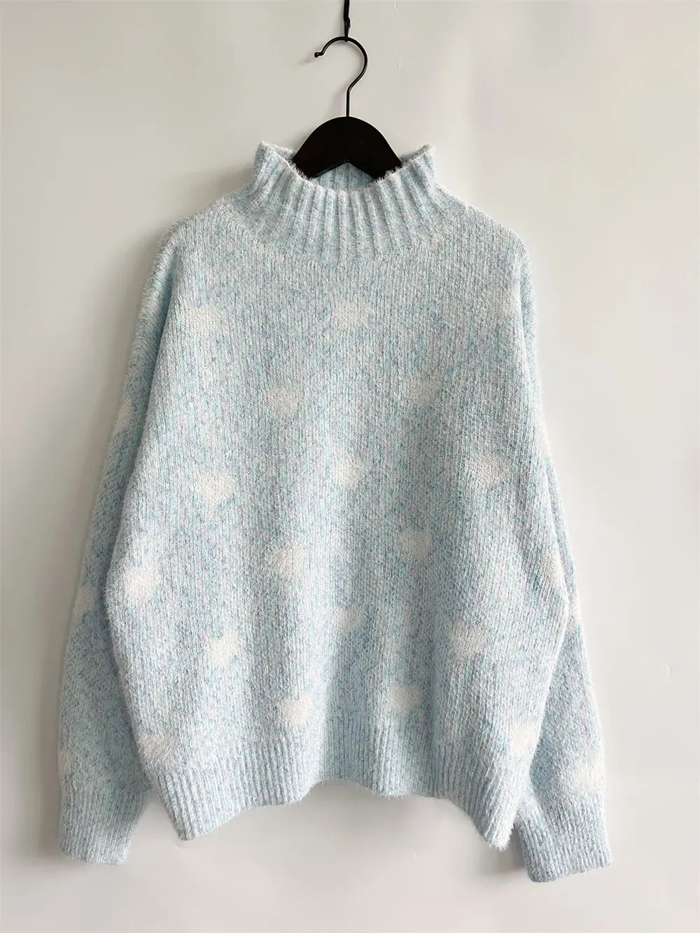 Heart-patterned heathered light blue turtleneck drop-shoulder sweater, hanging