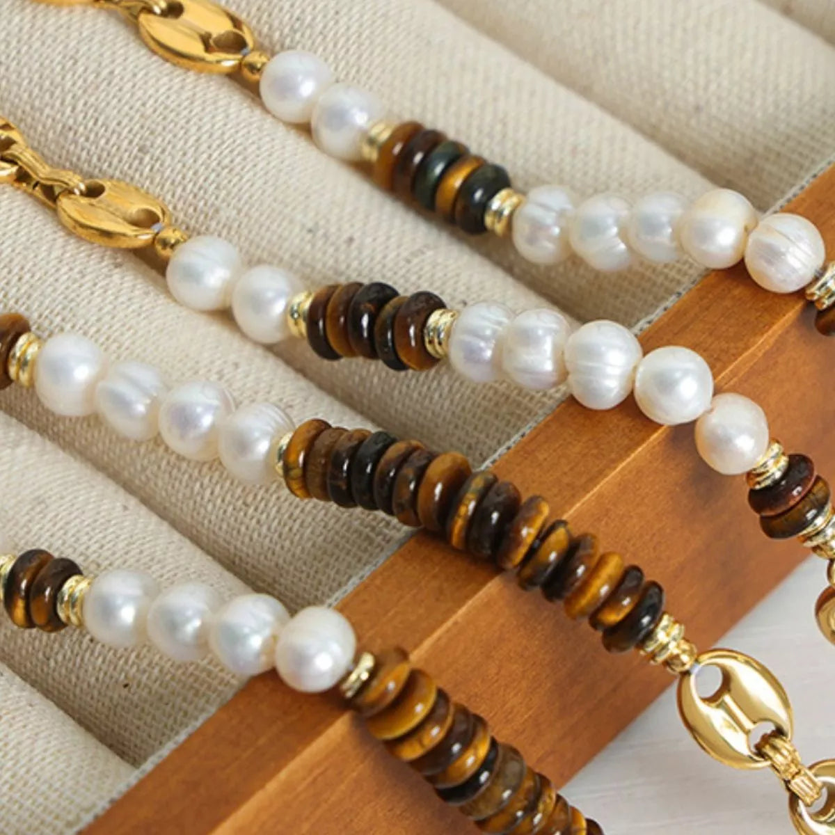 Freshwater pearl and tiger eye bead necklace detail with gold link clasp