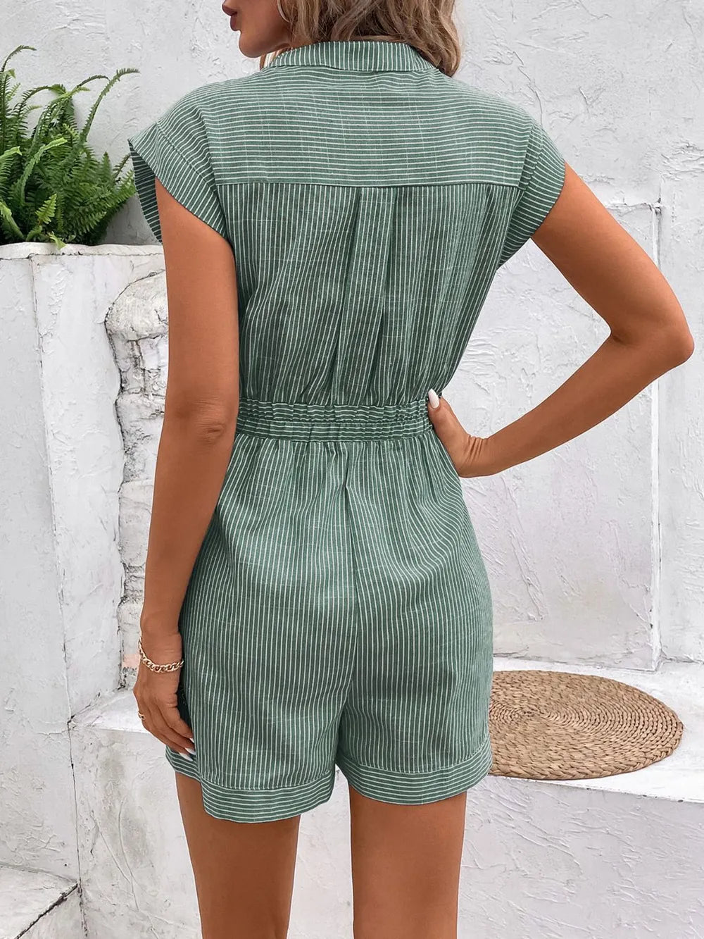 Striped notched tie-waist romper in green, short sleeves, back view with gathered waist
