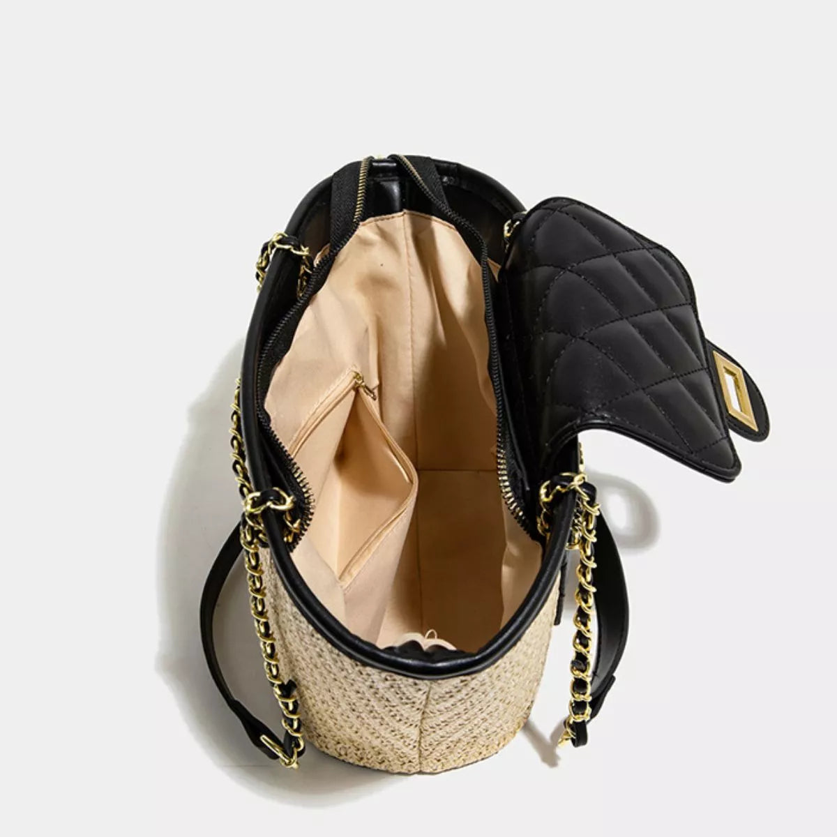 Woven straw shoulder bag with black quilted exterior and visible beige interior lining