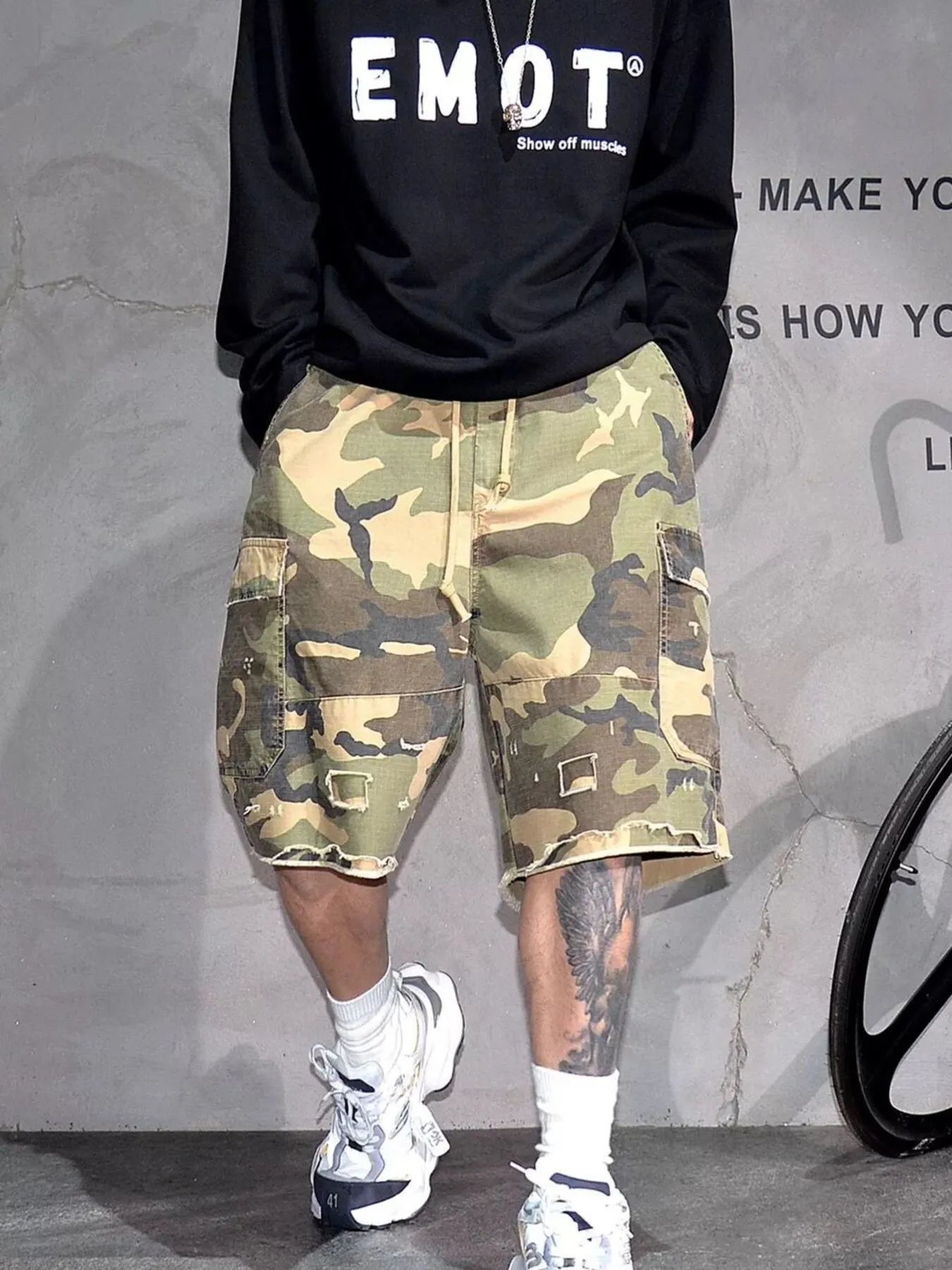 Light green camouflage cargo shorts with front zip and multiple utility pockets