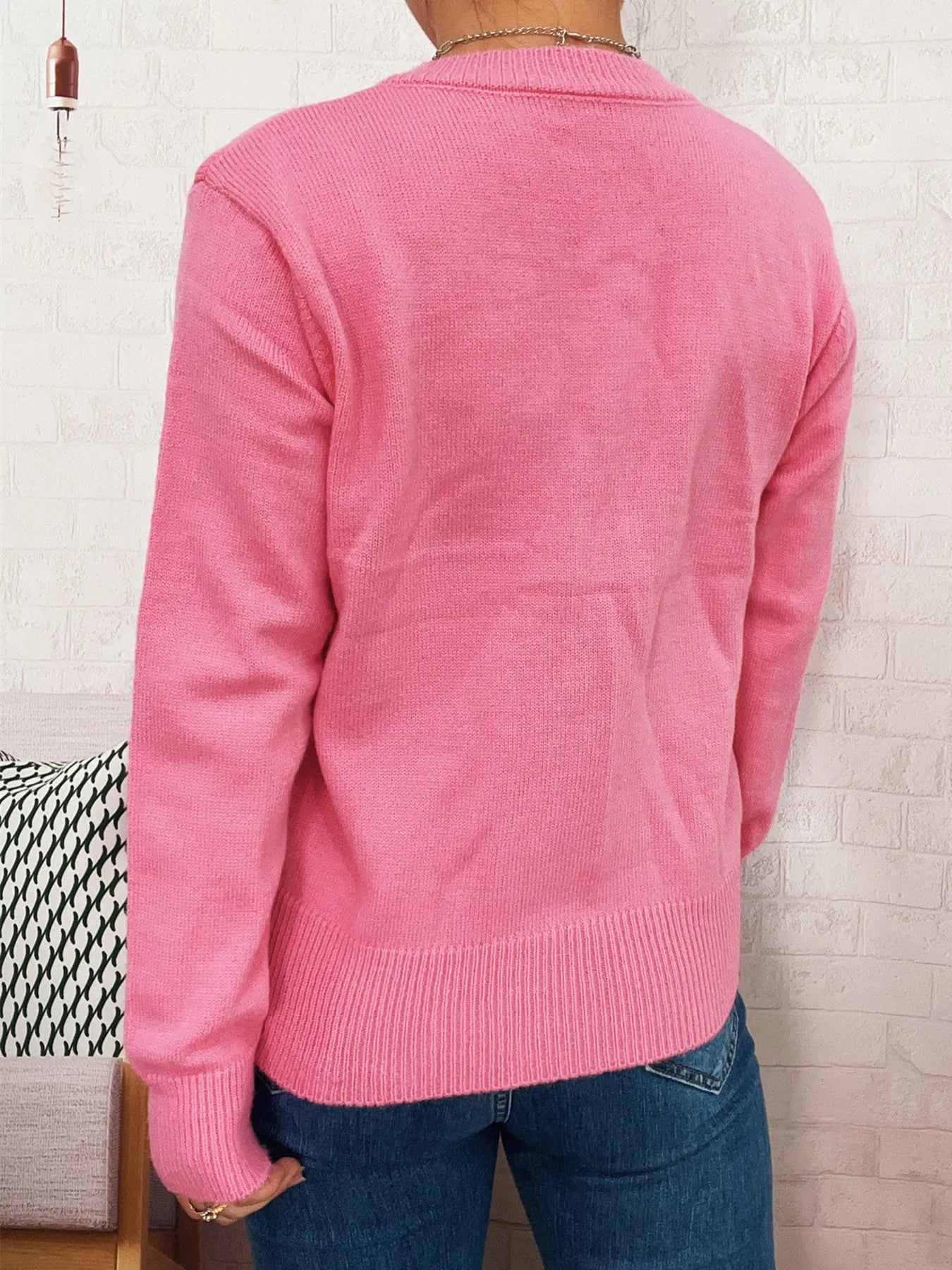 Pink button-back cardigan sweater with ribbed hem and long sleeves