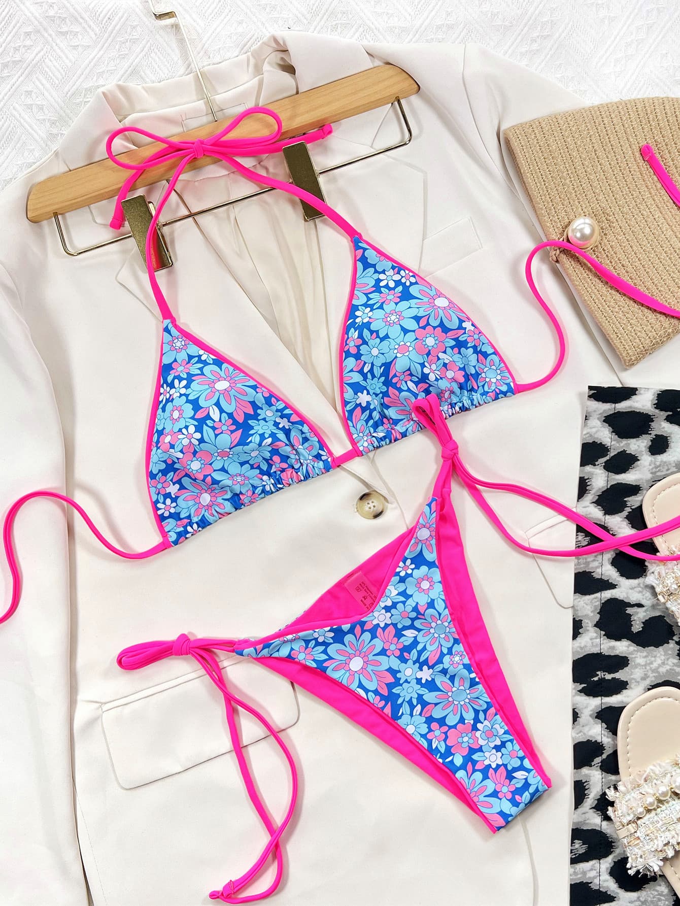 Floral triangle bikini top and tie-side bottoms on hangers, bright pink string ties