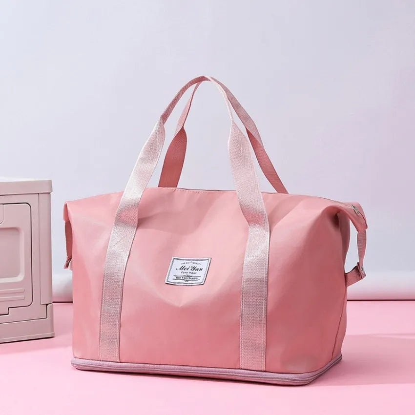 Large duffle bag with top handles, pink oxford cloth and gray trim, front label patch.