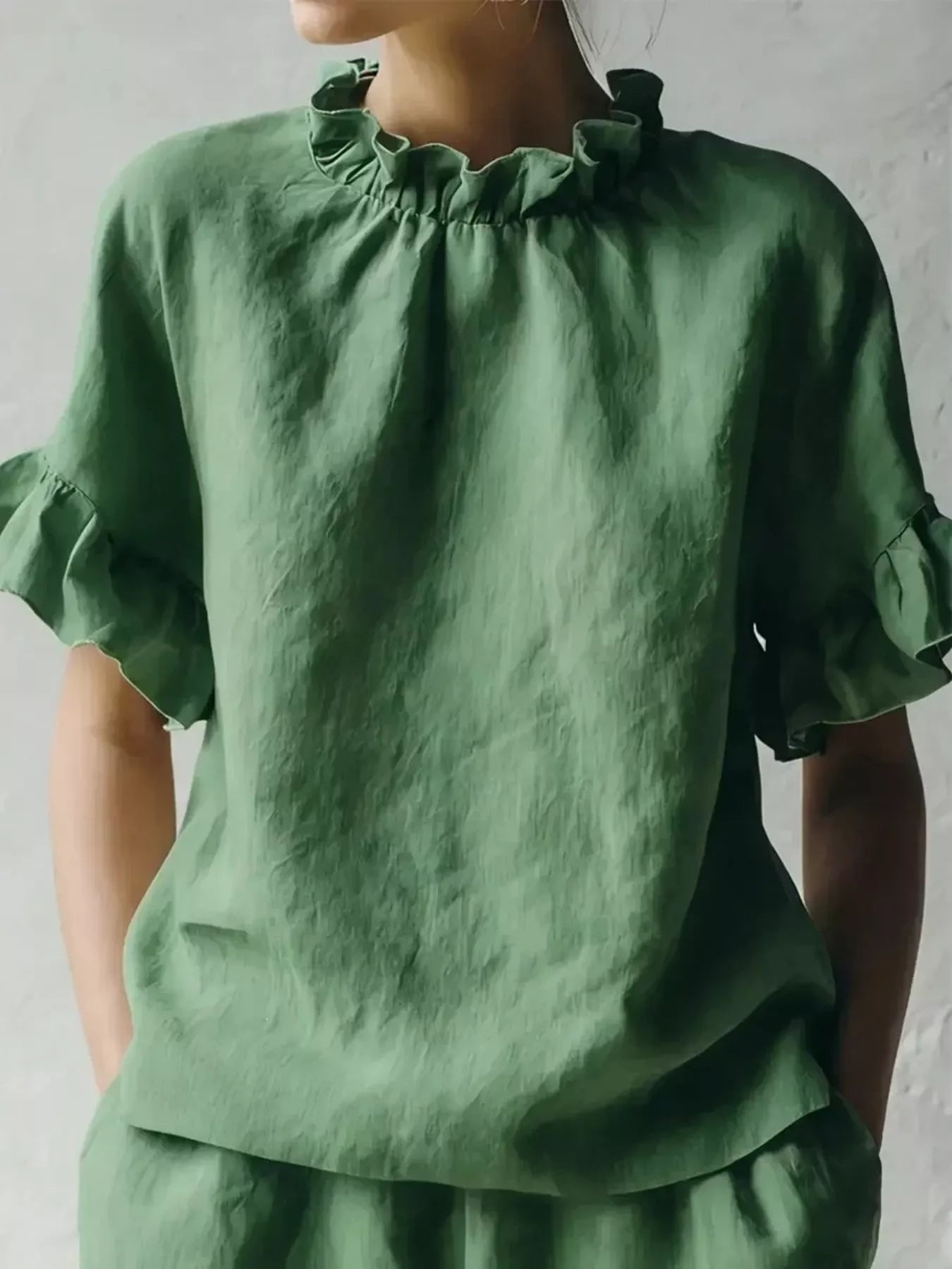 Green ruffled-neck half-sleeve blouse with gathered collar and pleated shoulders