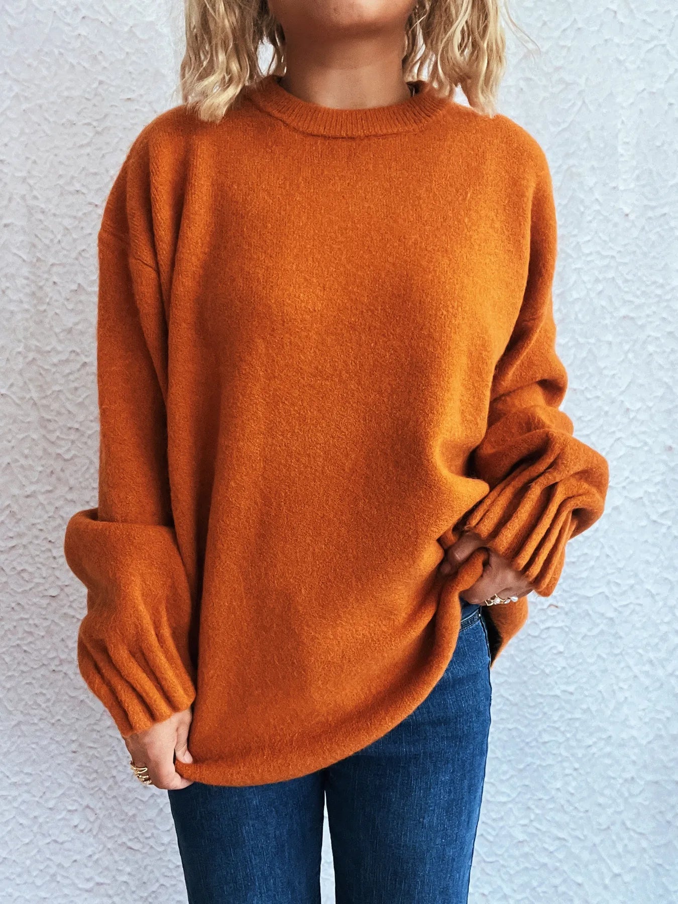 Orange dropped shoulder sweater with round neckline and ribbed sleeve cuffs