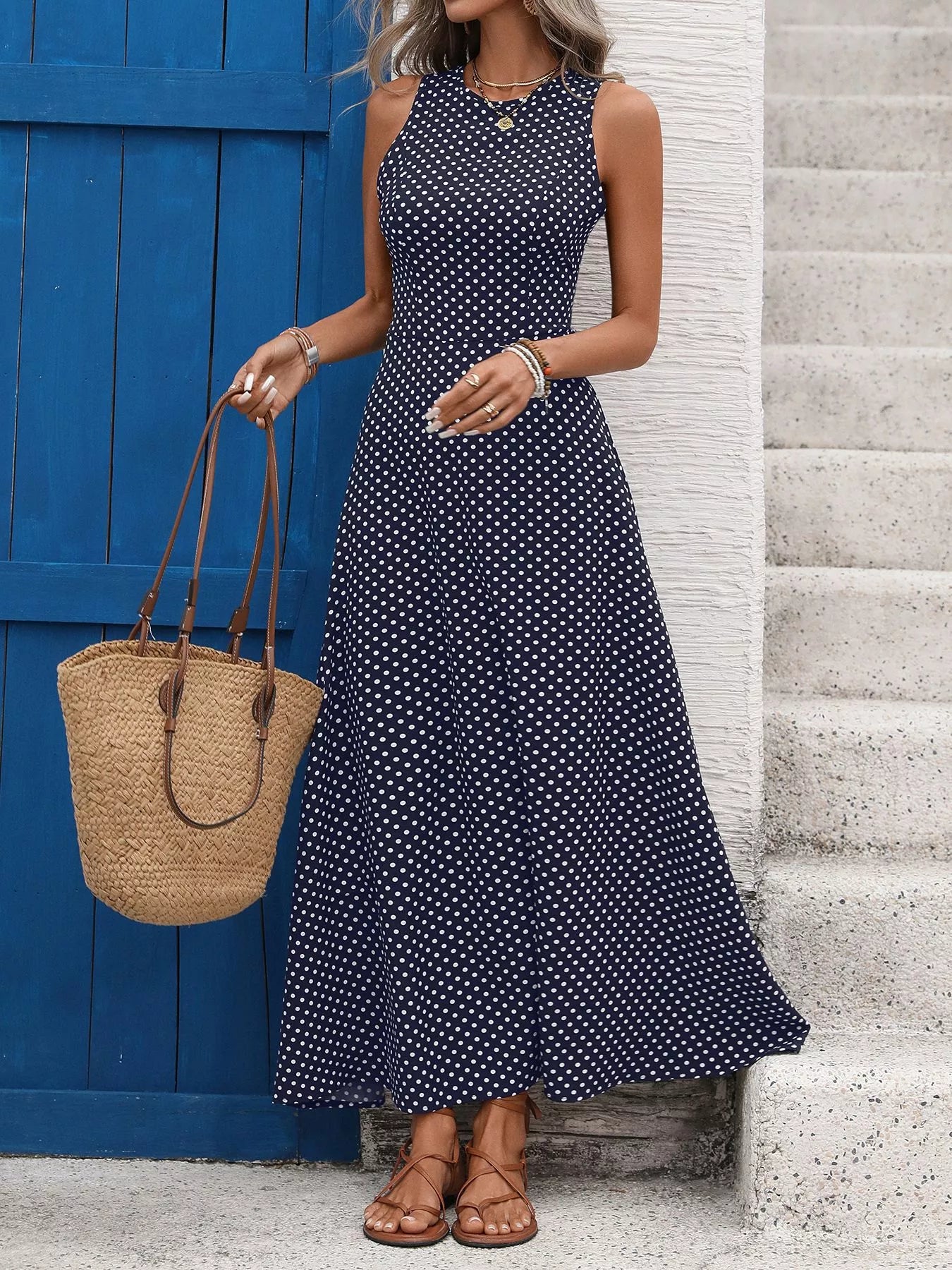 Cedar & Moore Sleeveless Polka Dot Maxi Dress navy with white dots, styled with straw tote.