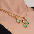 Gold-tone teardrop necklace with small green glass teardrop pendants