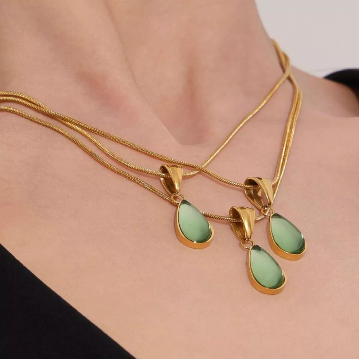 Gold-tone teardrop necklace with small green glass teardrop pendants