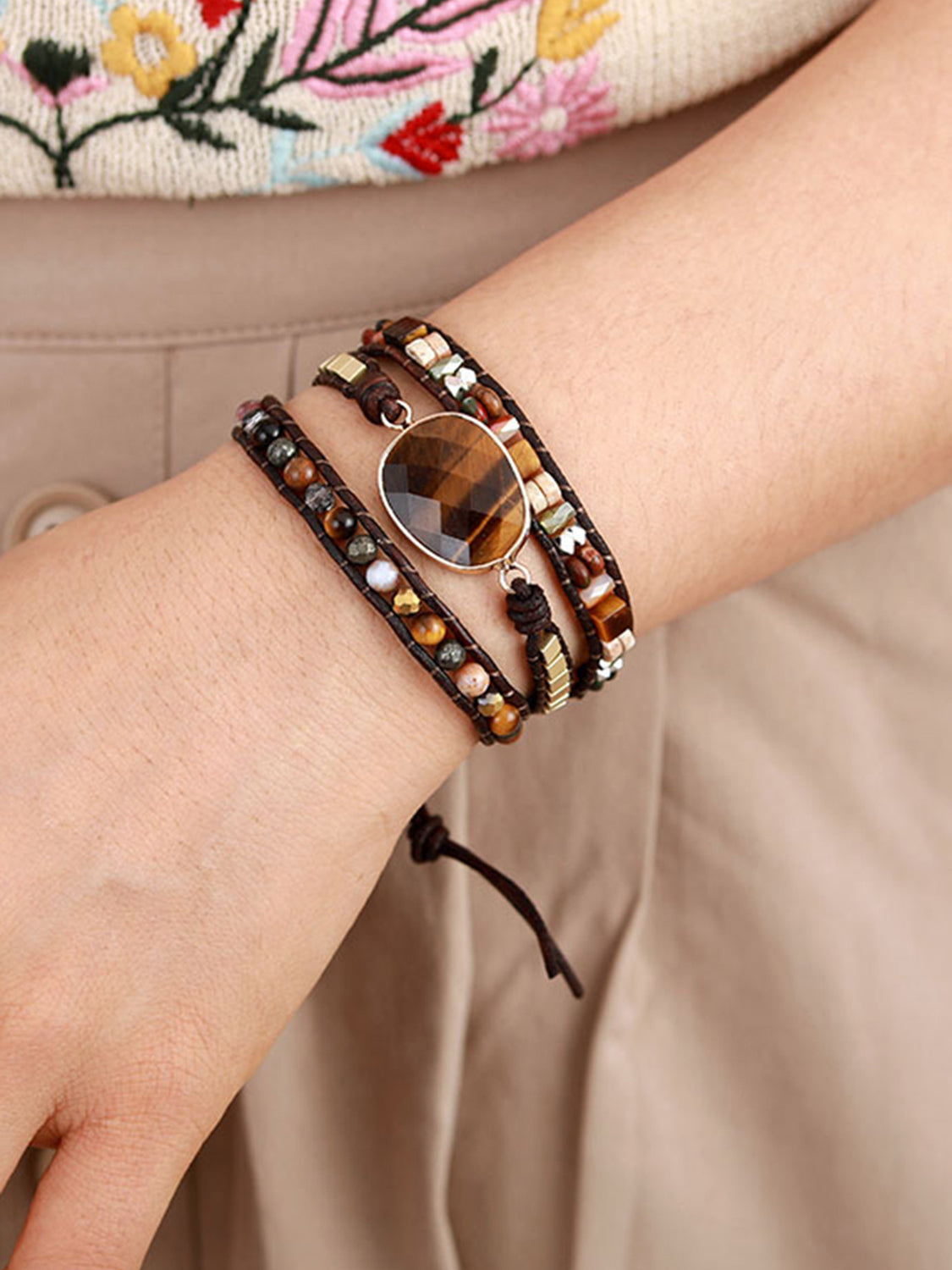 Triple-layer bracelet with oval wood charm and wraparound beads, worn on wrist