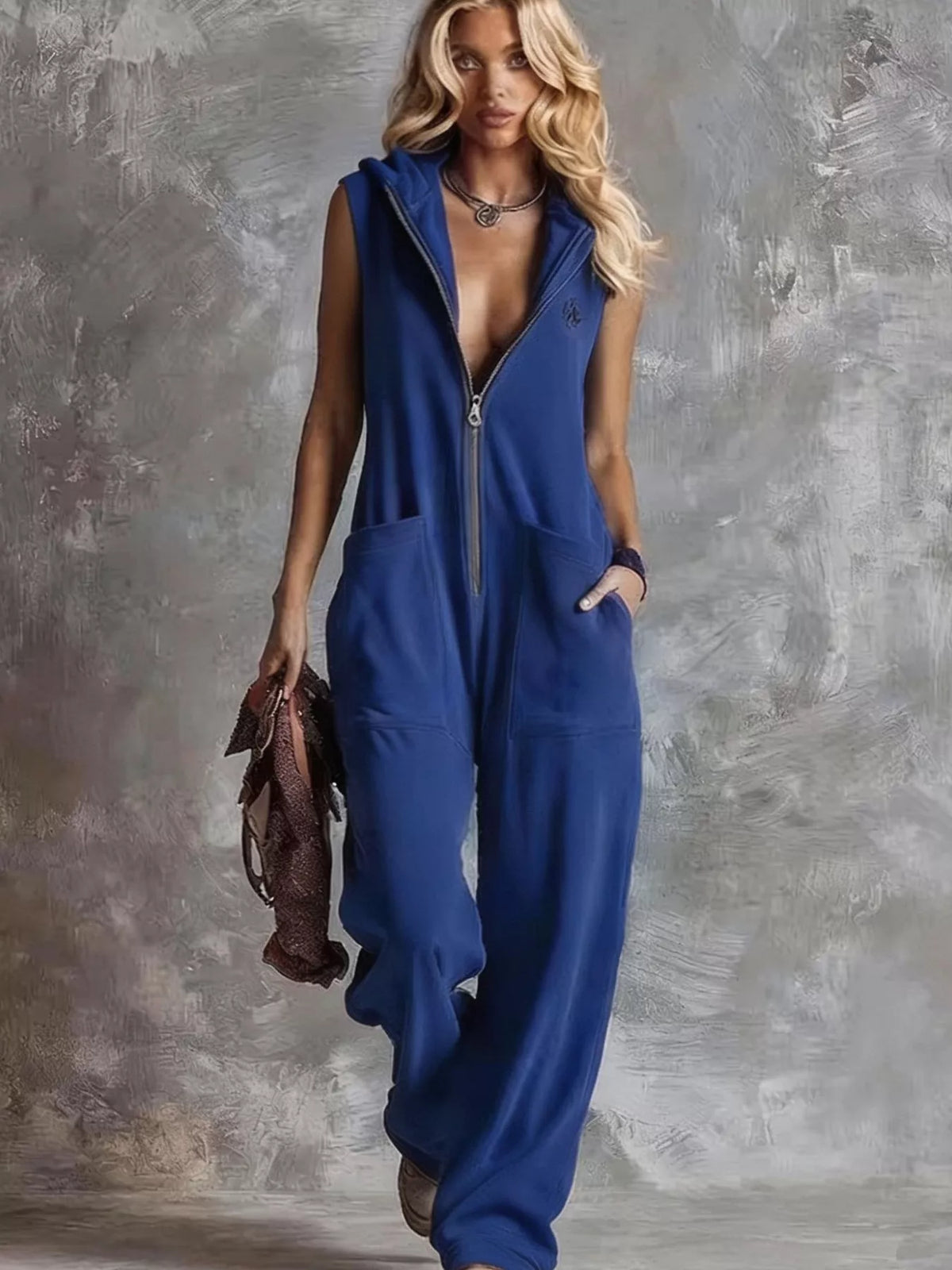 Dark blue sleeveless hooded zip jumpsuit with front pockets and loose, full-length legs