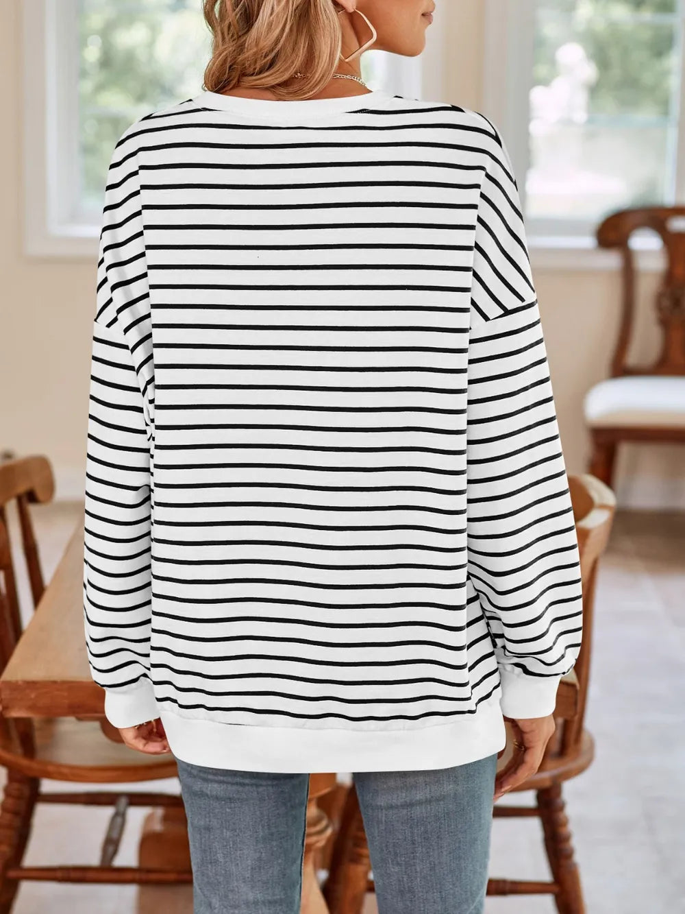 Back view of white and black striped round-neck long-sleeve sweatshirt