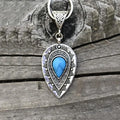 Silver pendant necklace with teardrop geometric charm and blue oval stone