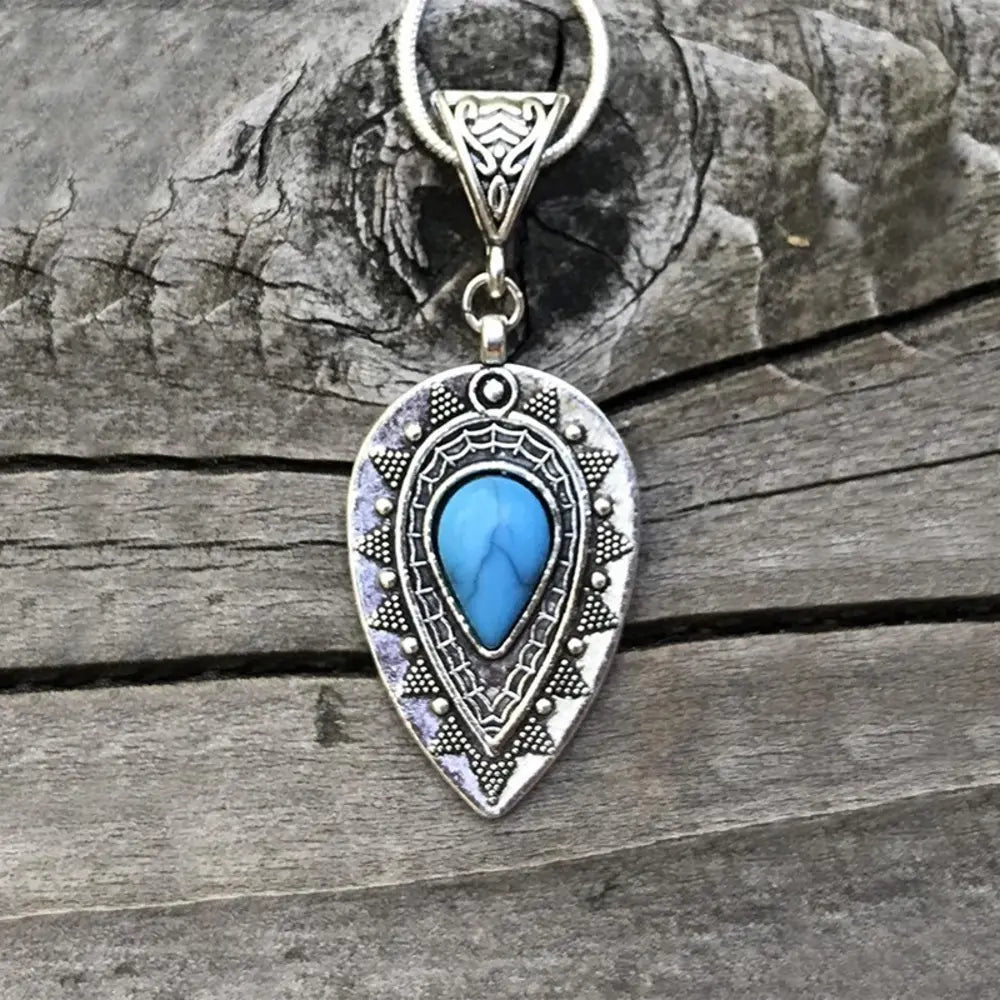 Silver pendant necklace with teardrop geometric charm and blue oval stone