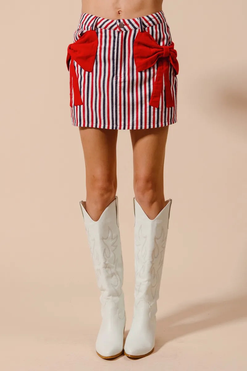 Striped denim skirt with red bow-knot side pockets and tassel details, above-knee