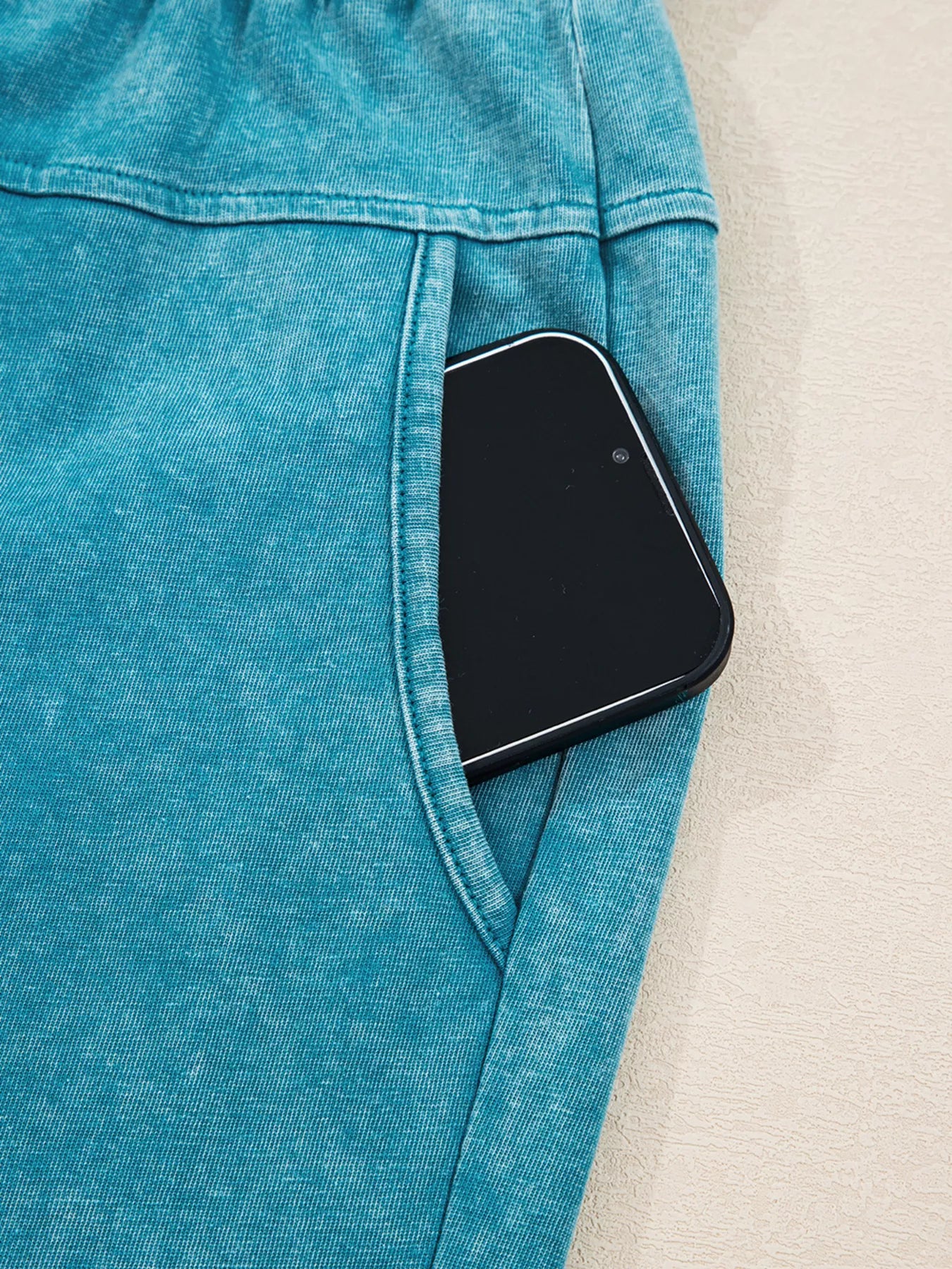 Teal patch pocket pants with phone-sized pocket opening and stitched trim