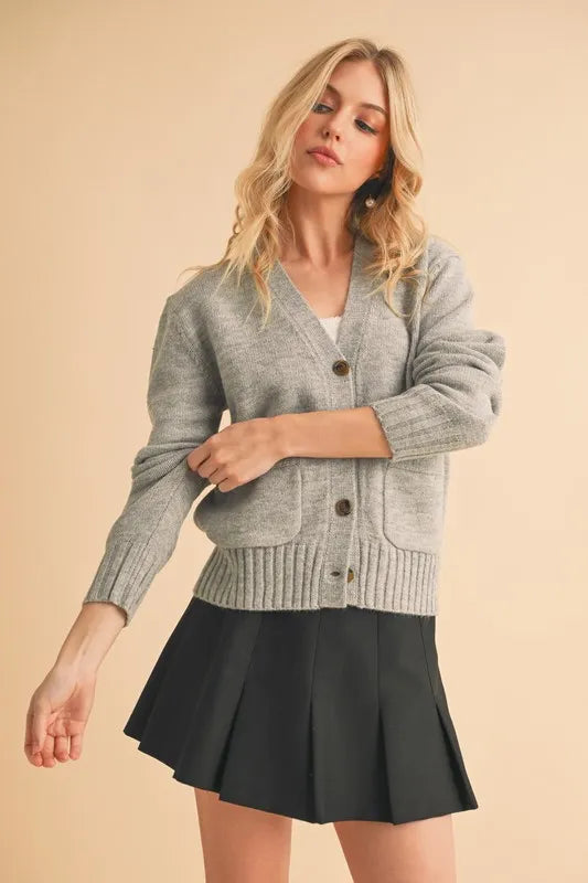 Gray V-neck button cardigan with front patch pockets and ribbed waistband