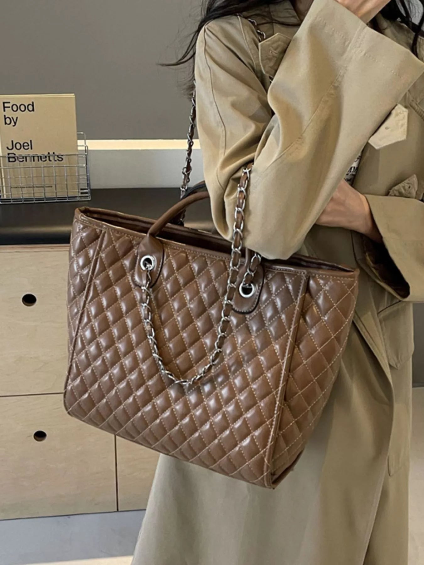 Brown quilted medium shoulder bag with chain strap, metal hardware, and structured top