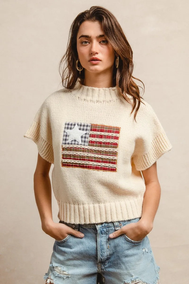 Oatmeal knit sweater with drop shoulders, short sleeves, and American flag patch on chest