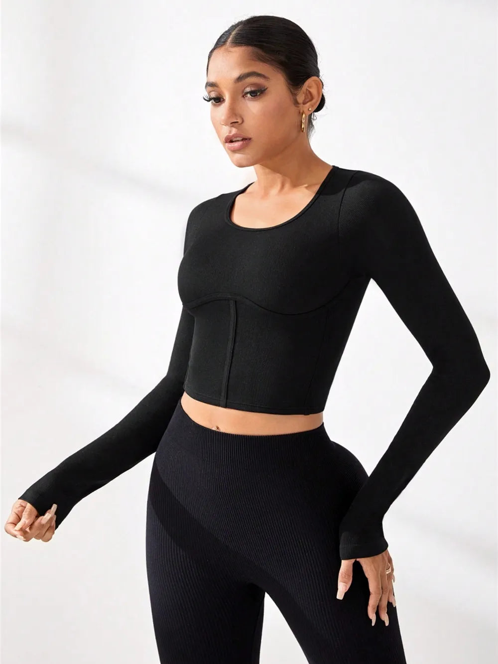 Black round-neck long-sleeve active t-shirt with curved hem, cropped