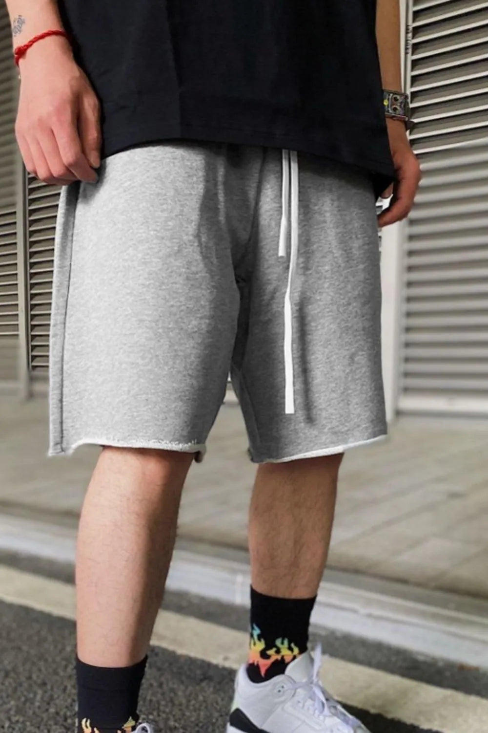 Gray drawstring shorts with elastic waistband and white drawcord, above-knee length.