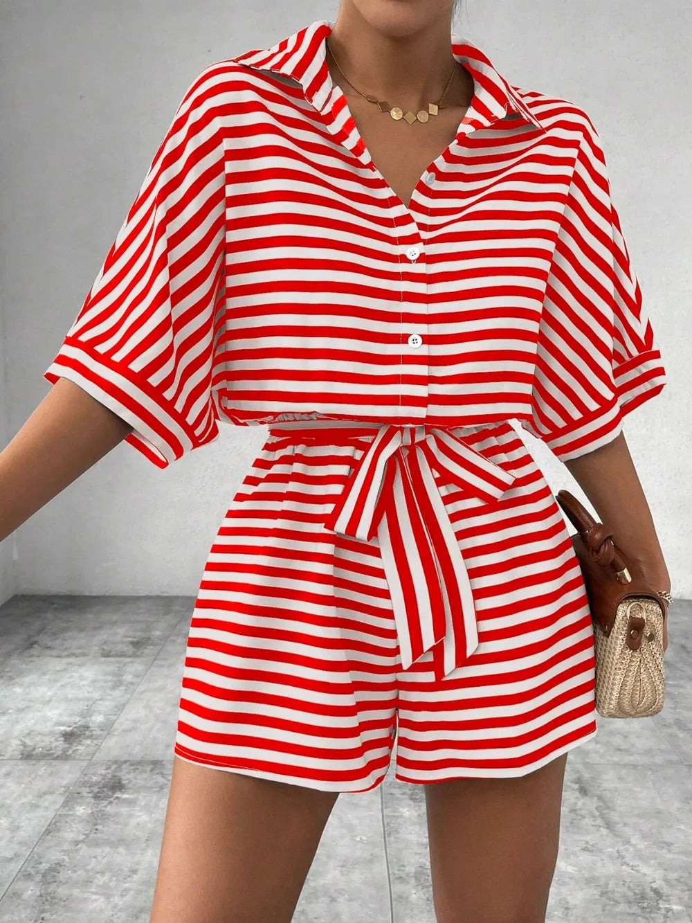 Red and white striped button-front romper with tie waist and cuffed short sleeves