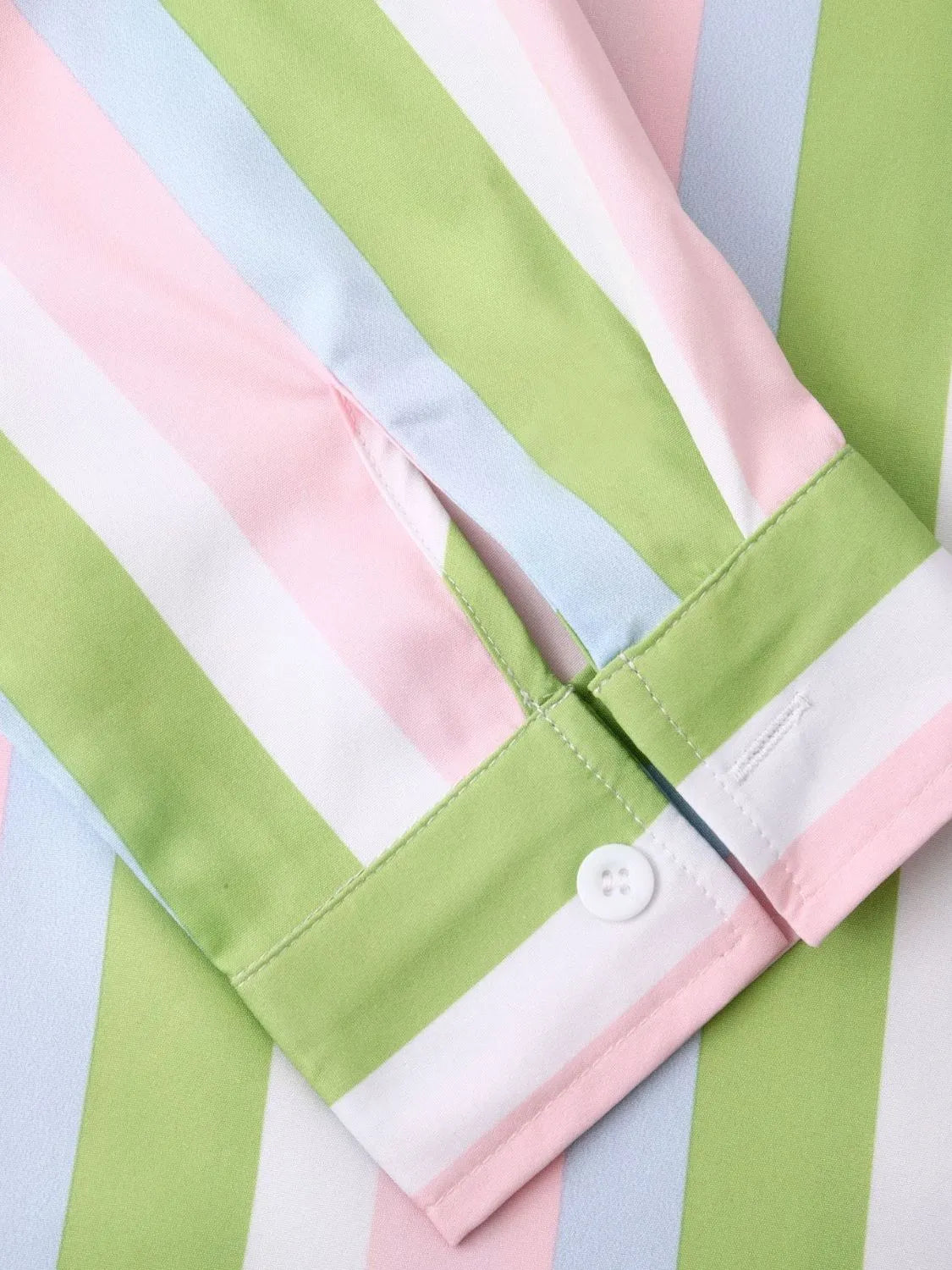Sleeve cuff placket detail on striped button-up shirt, pastel green, pink, and white