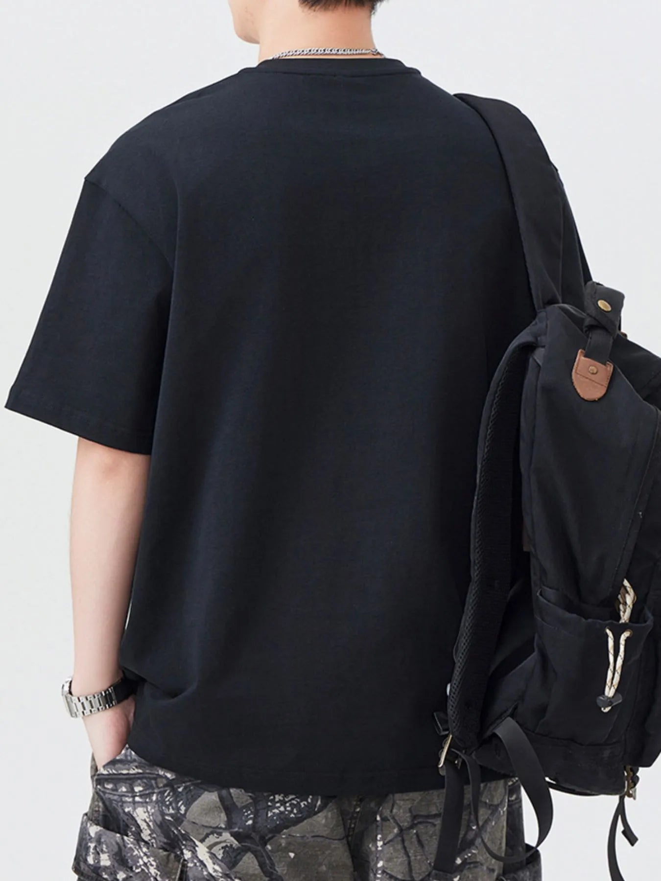 Black oversized half-zip T-shirt, back view with short sleeves and zipper
