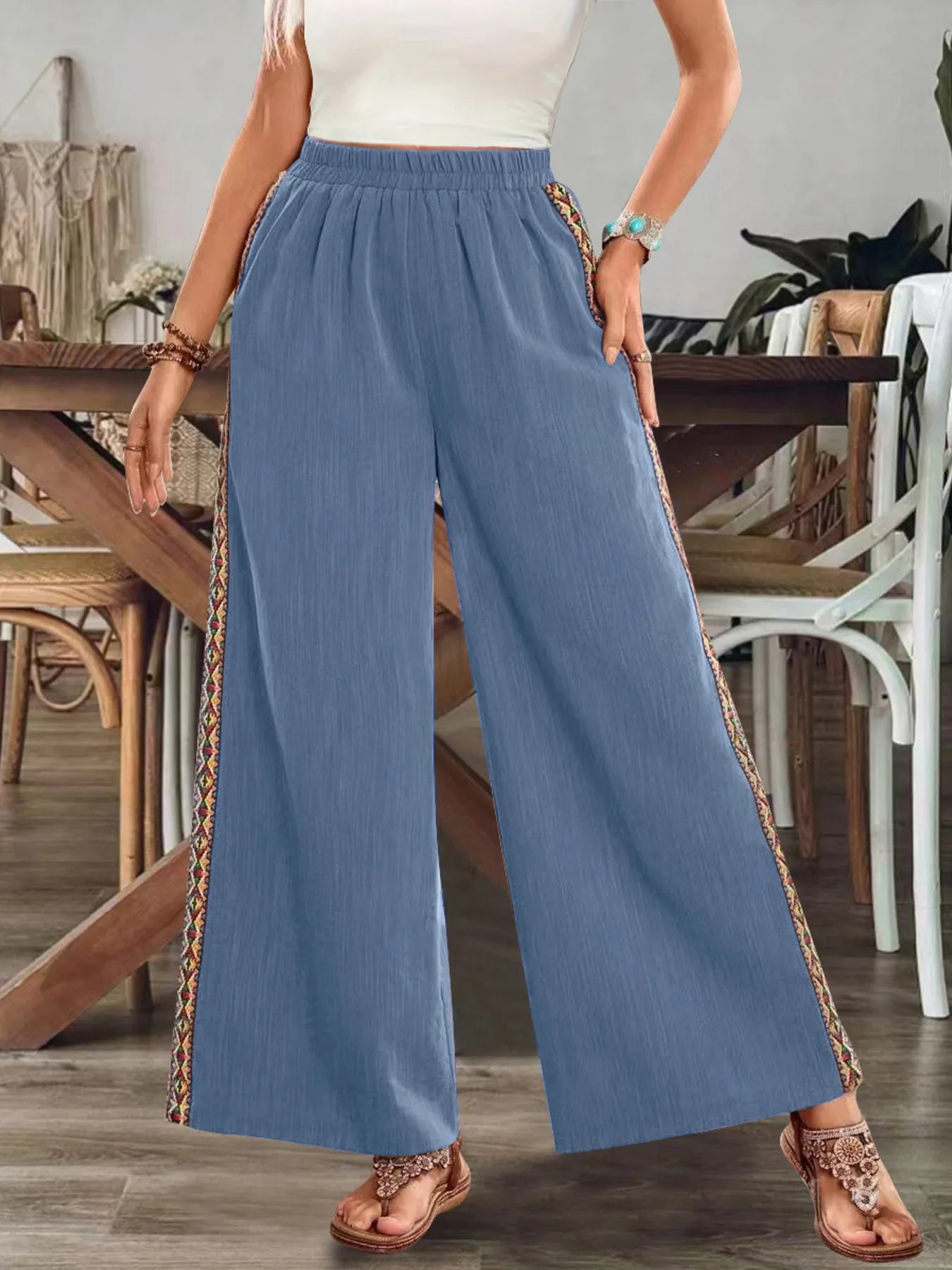 Blue wide-leg pants with elastic waist and embroidered side stripe along the leg.