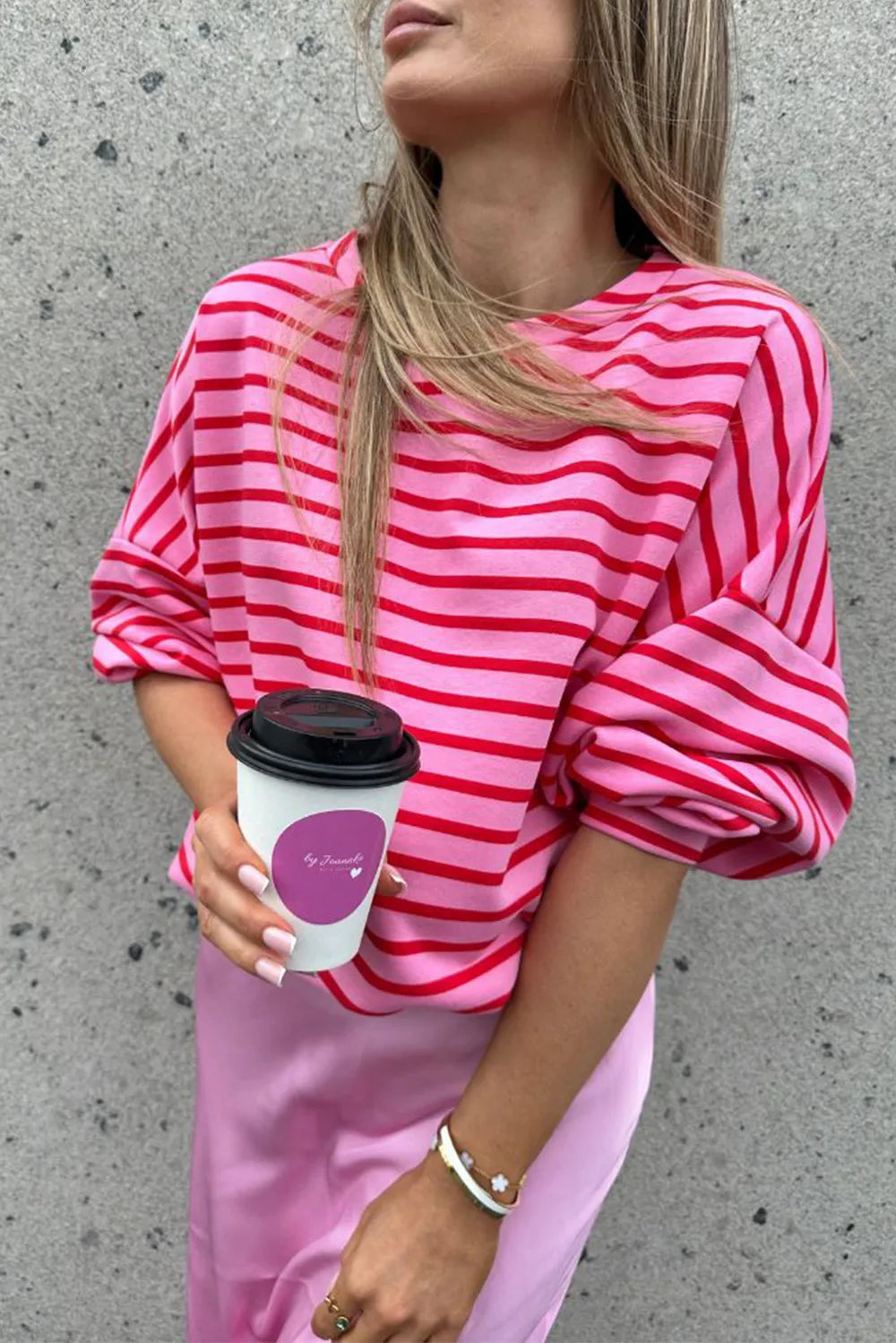 Hot pink striped round-neck long-sleeve sweatshirt with relaxed fit and cuffed sleeves.
