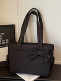 Black medium casual tote bag with front bow accent and wide handles