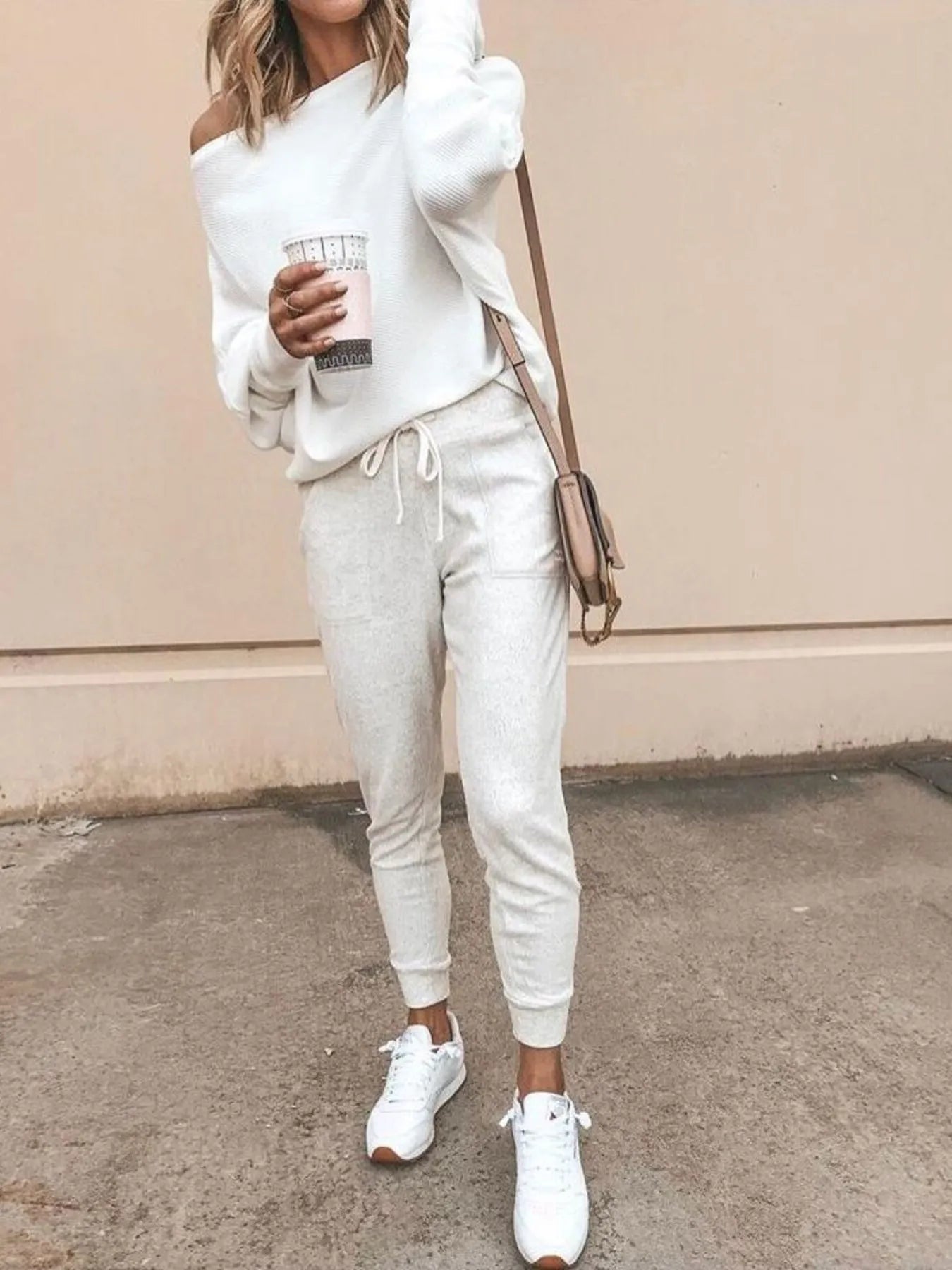White one-shoulder ribbed knit sweater with relaxed fit and long sleeves.