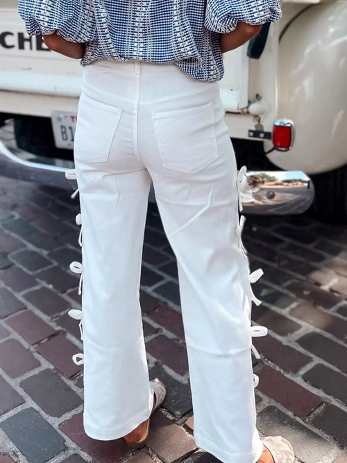 White wide-leg pants with bow ties at the outer seams
