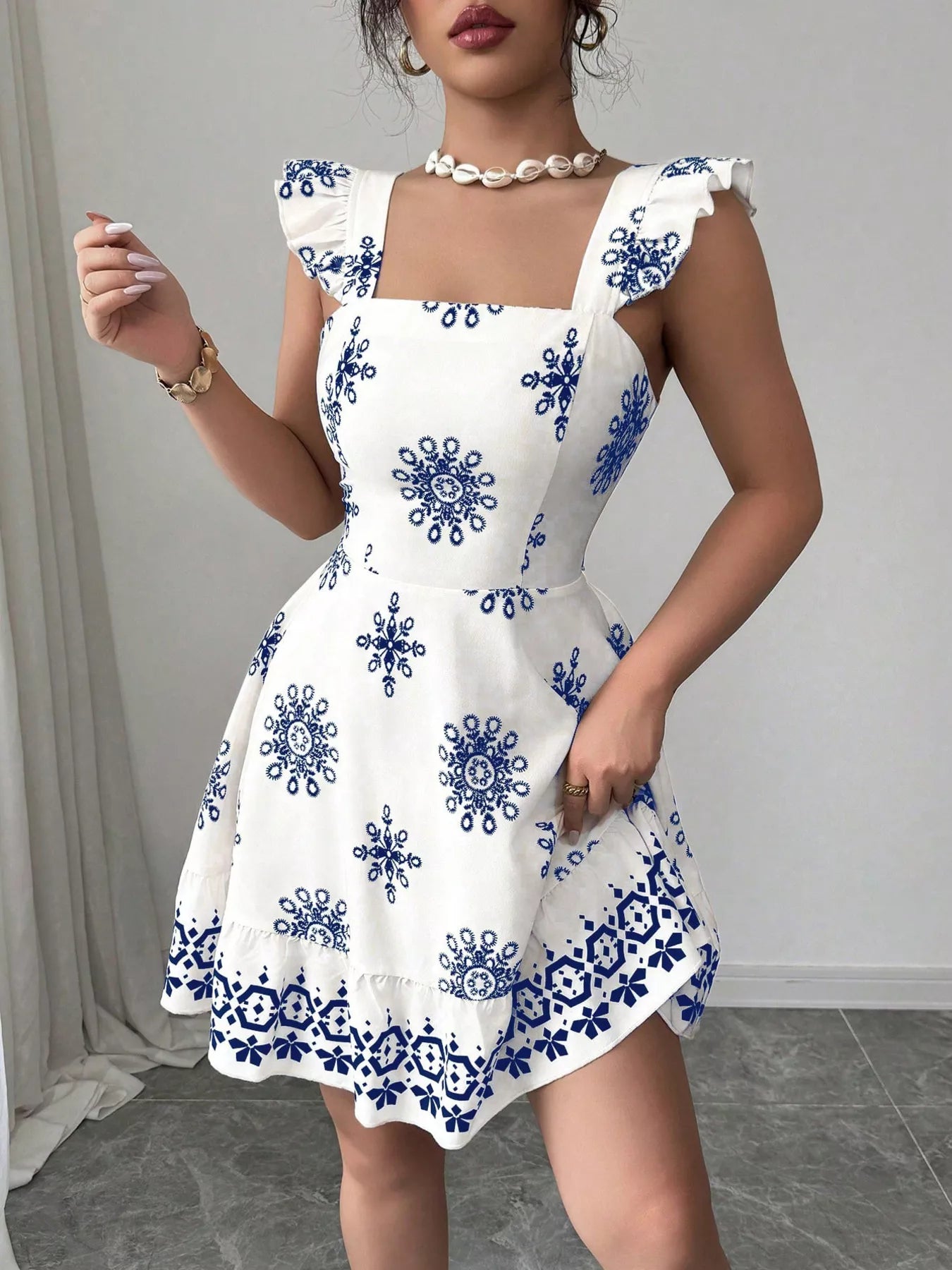 Printed mini dress with square neckline, ruffled sleeves, and blue motif pattern
