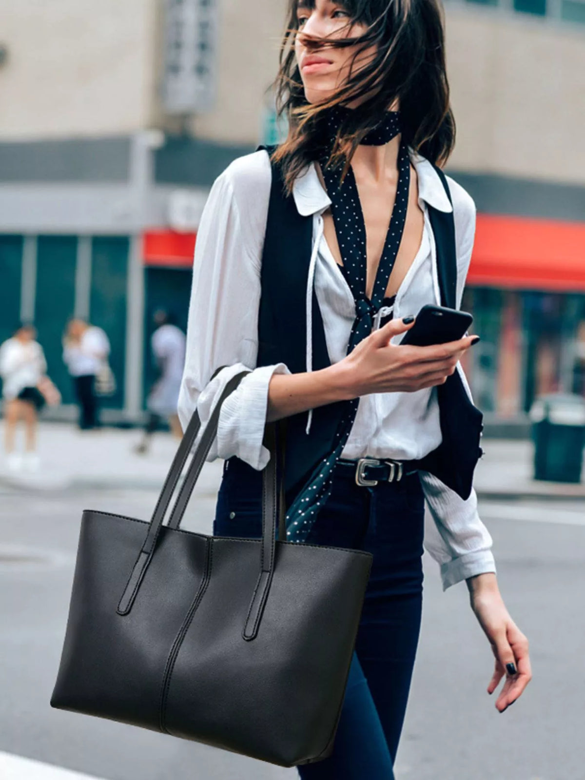Black medium vegan leather tote bag with two long handles and structured shape